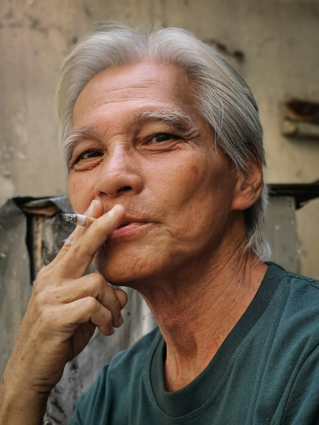 Studio portrait of a woman in her fifties with short gray hair and a warm confident smile
